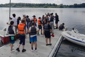 Morgendliches Briefing am Steg. Die Trainer erklären, wie heute gesegelt wird.